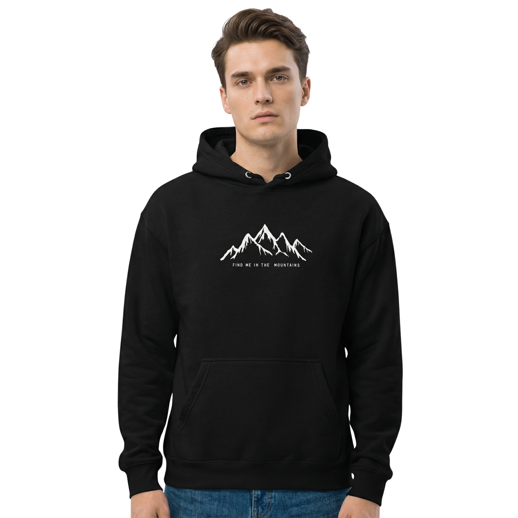 Man wearing a black pullover hoodie featuring the 'Find Me In The Mountains' design. The ultimate mountain hoodie for essential nature clothing made by Natura Nation.
