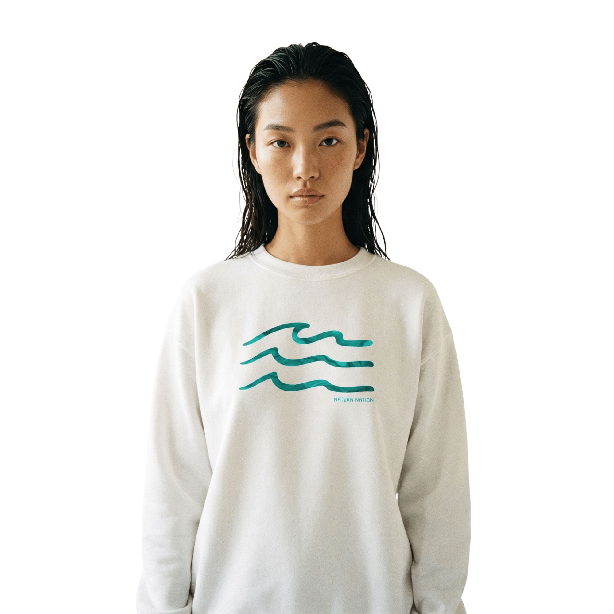 Female model wearing a white Ocean Sweatshirt featuring the 'Serenity Waves' design. This pristine Ocean Clothing is perfect for peaceful coastal days. Made by Natura Nation.