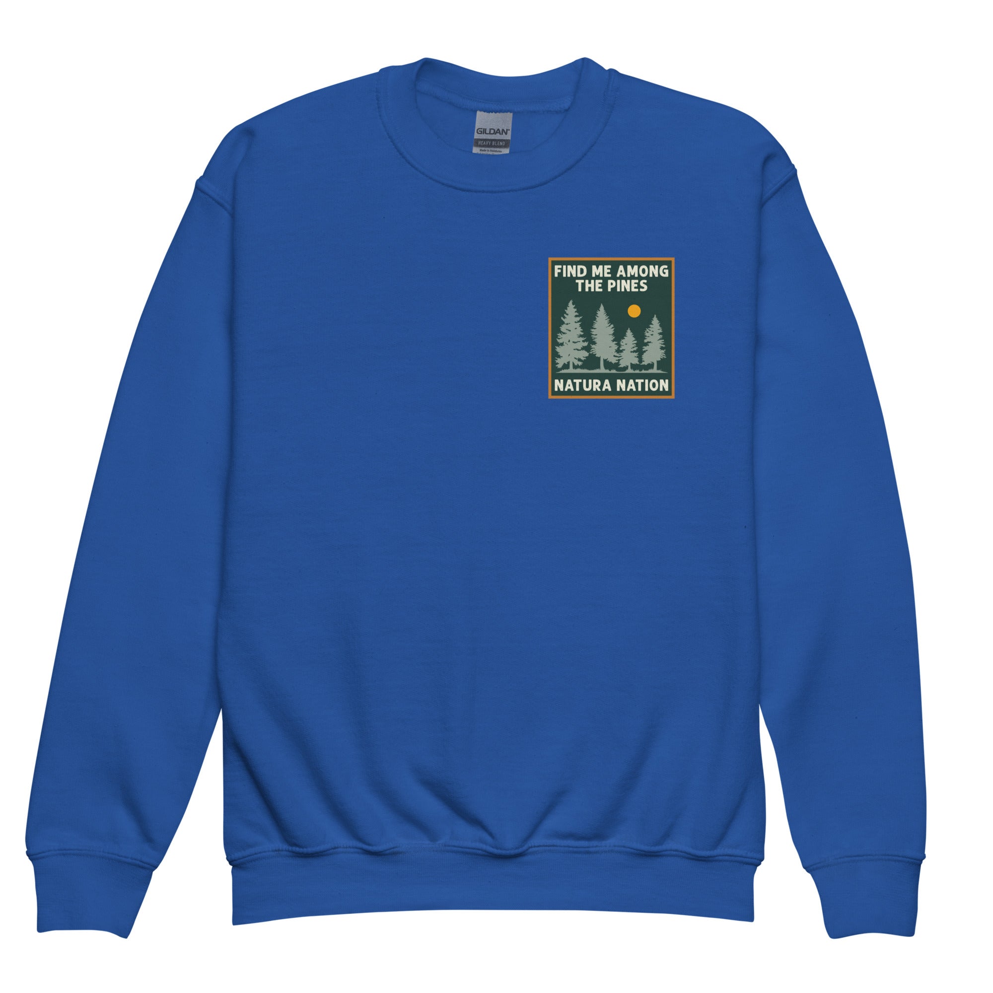 A royal blue crewneck sweatshirt with a rectangular chest graphic on the left side. The graphic features a forest scene with pine trees, a small yellow sun, and the text 'FIND ME AMONG THE PINES' above and 'NATURA NATION' below. Youth forest sweatshirt with a nature pine print and cozy fleece for cooler days.